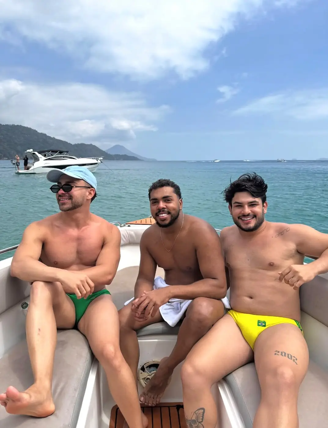 Três amigos sentados no cockpit da lancha