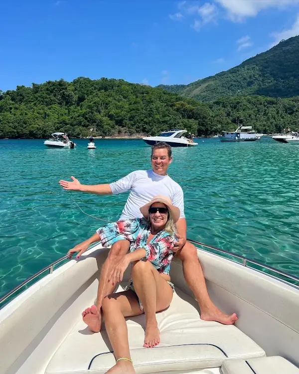 Casal sentado na proa da lancha