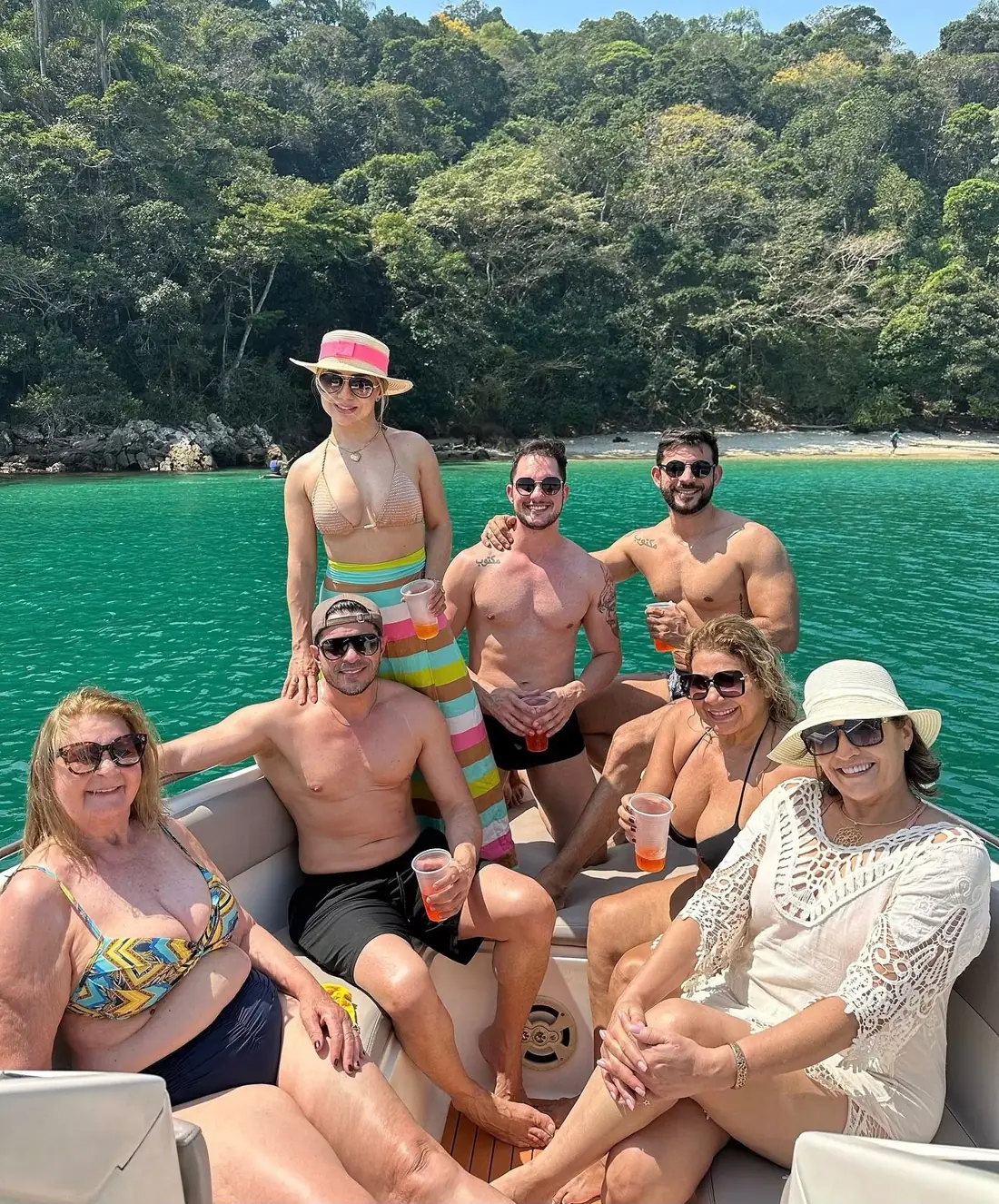 Grupo de amigos na lancha em frente a uma praia
