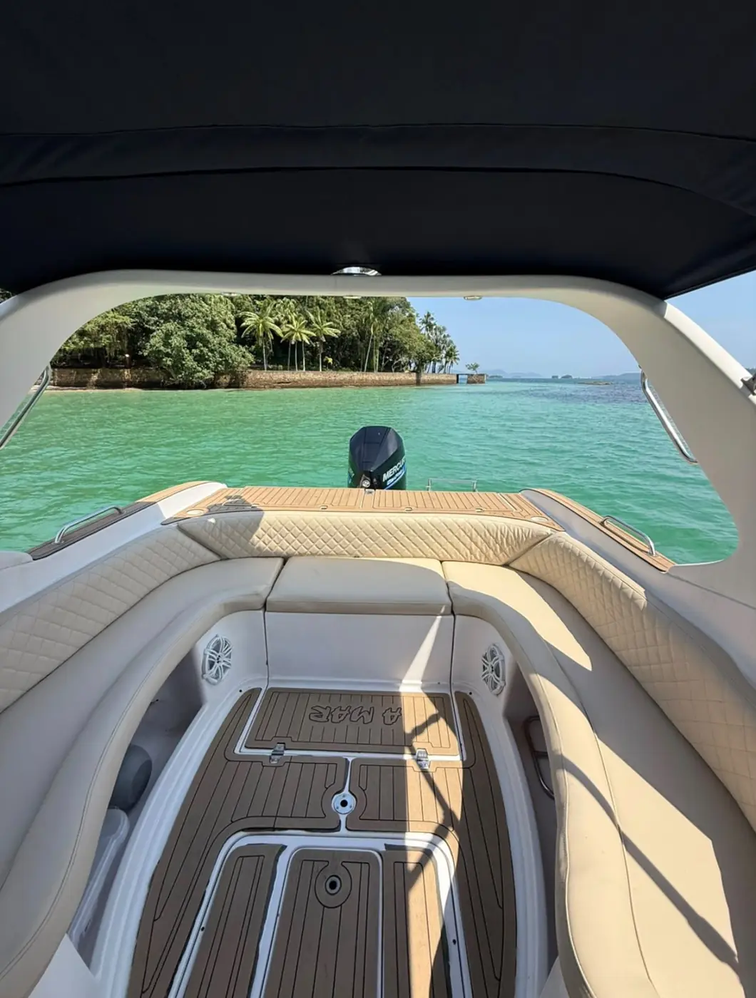 Cockpit com estofados e piso de teca, de frente para uma ilha